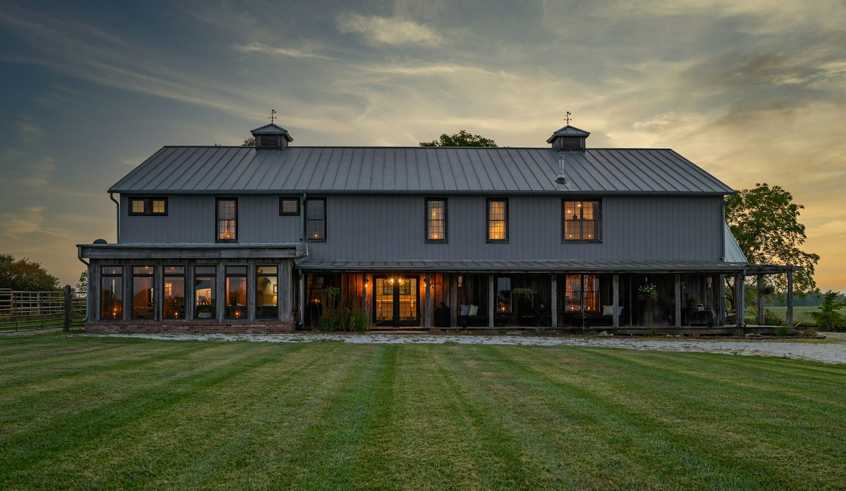Braunes und schwarzes Holzhaus auf grüner Wiese bei Tageslicht